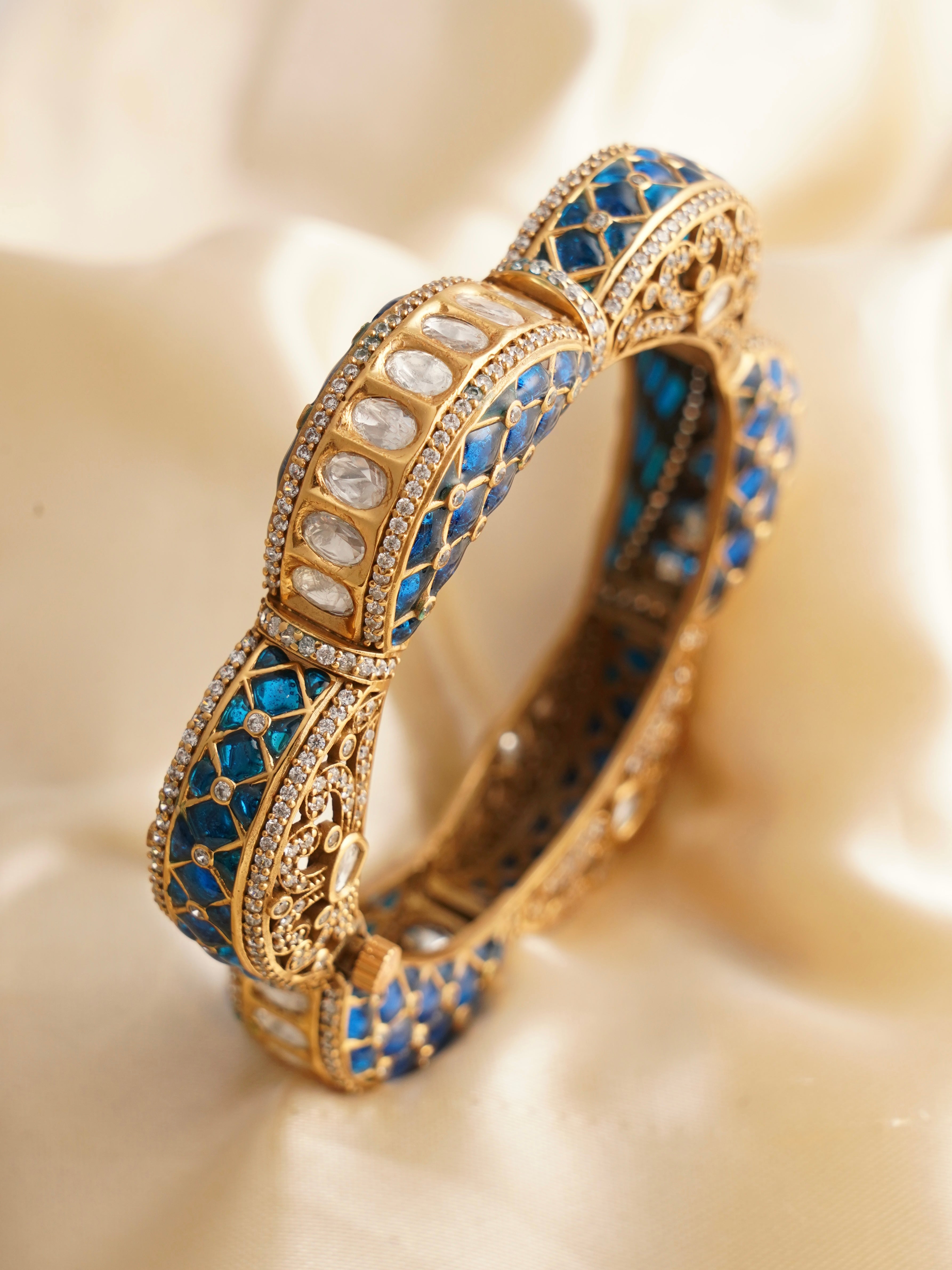 Openable kada bangle with alternating ruby and emerald inlays and kundan detailing